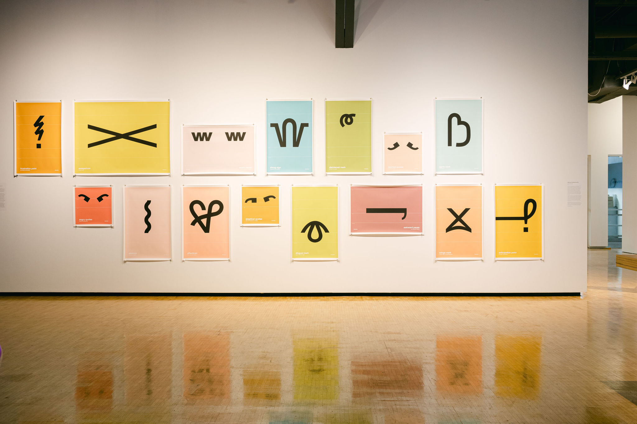 Colorful posters with abstract black symbols on a gallery wall