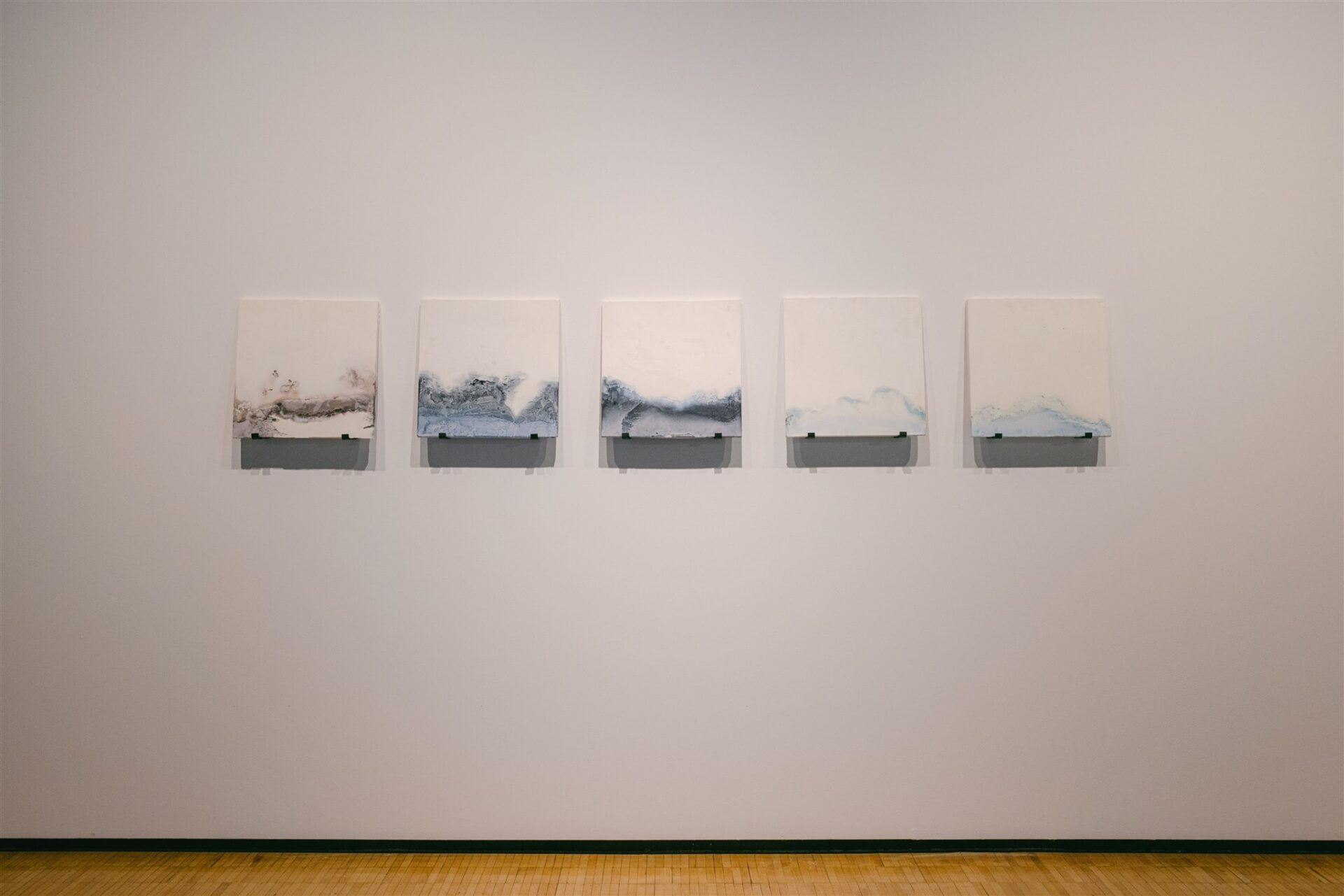 Five abstract white panels with soft blue and brown textures