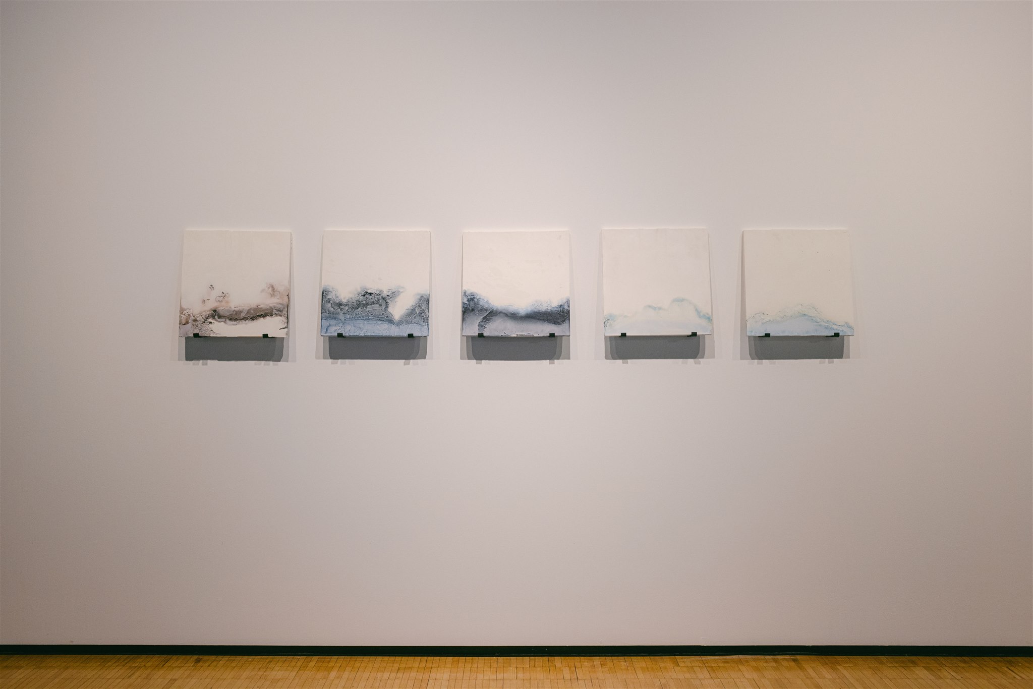 Five abstract white panels with soft blue and brown textures