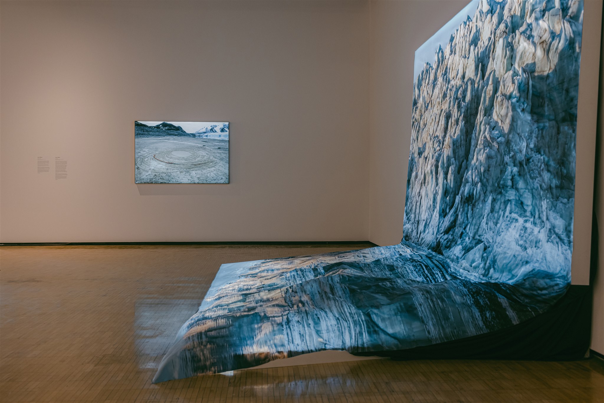 Large glacier photo draped onto the wall and floor, with another framed photo nearby