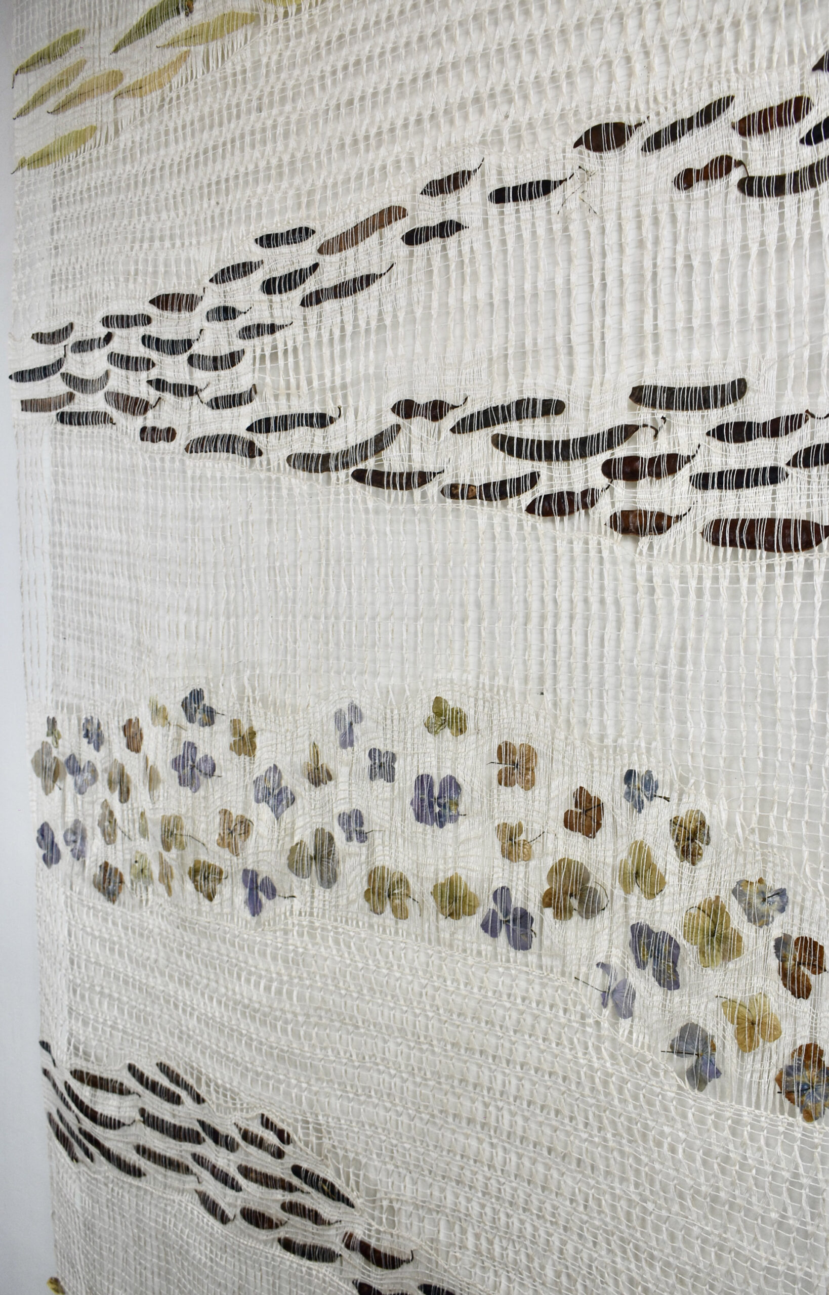 Open weave linen textile with embedded plant materials