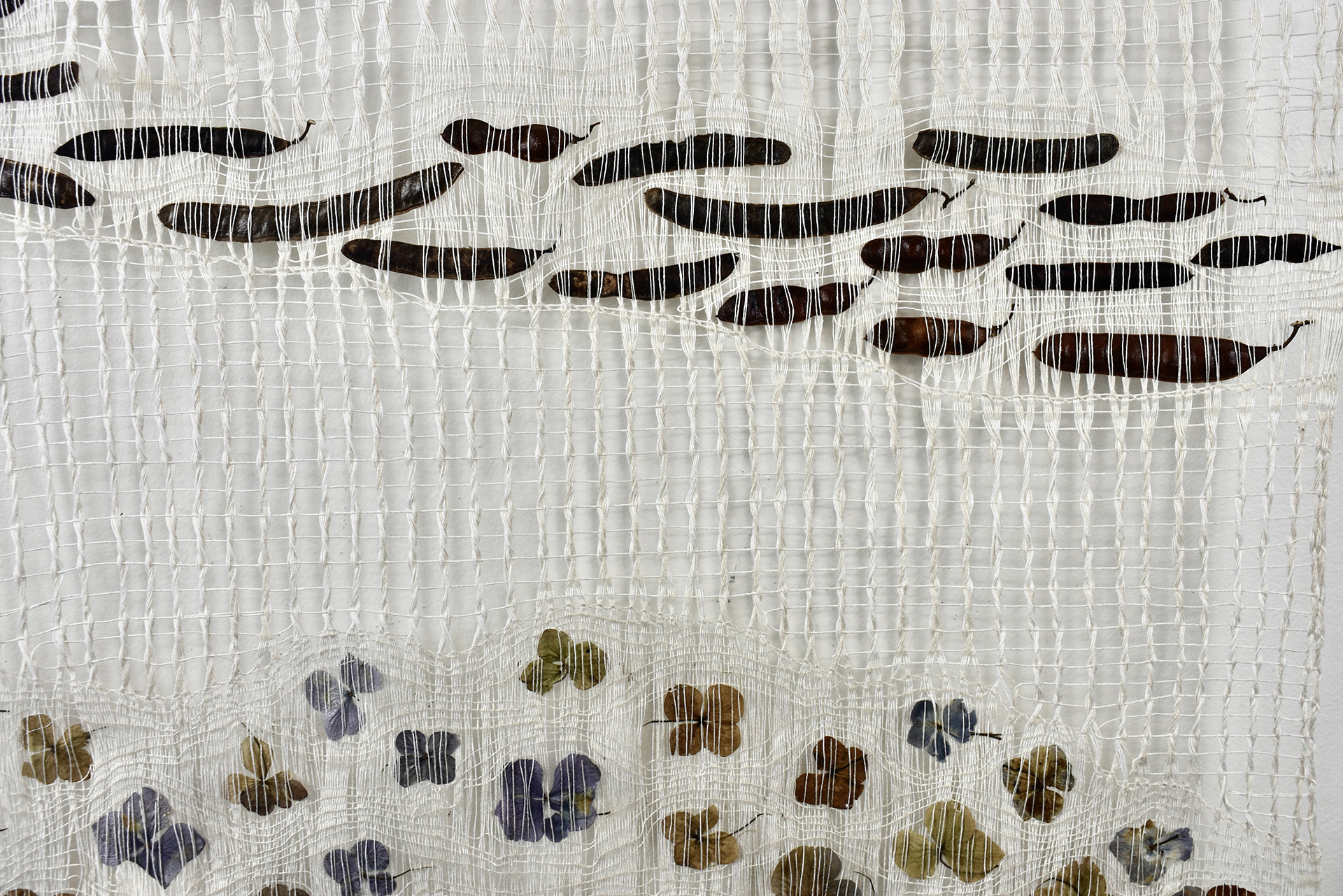 Open weave linen textile with embedded plant materials