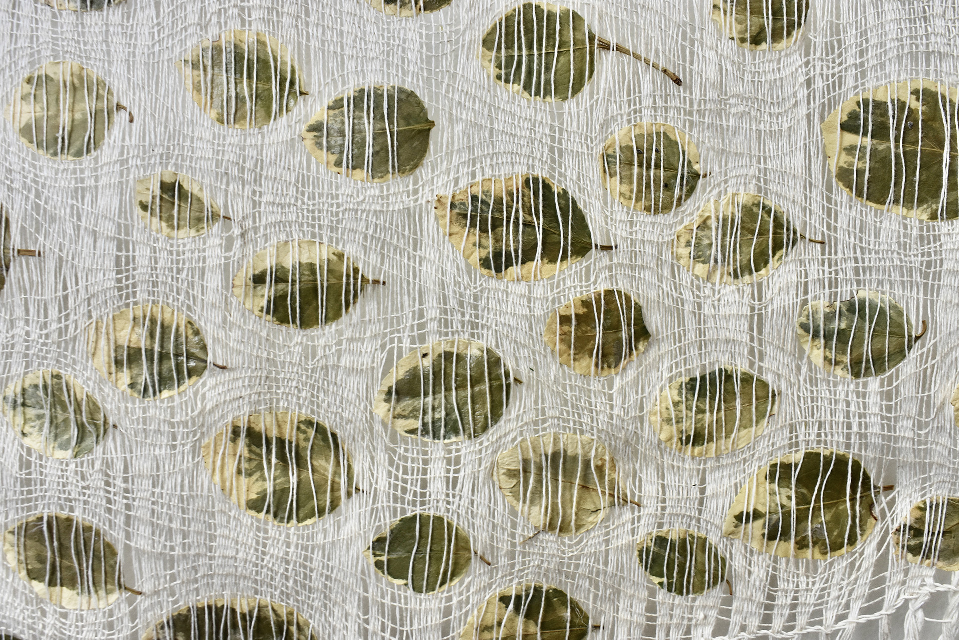 Open weave linen textile with embedded plant materials