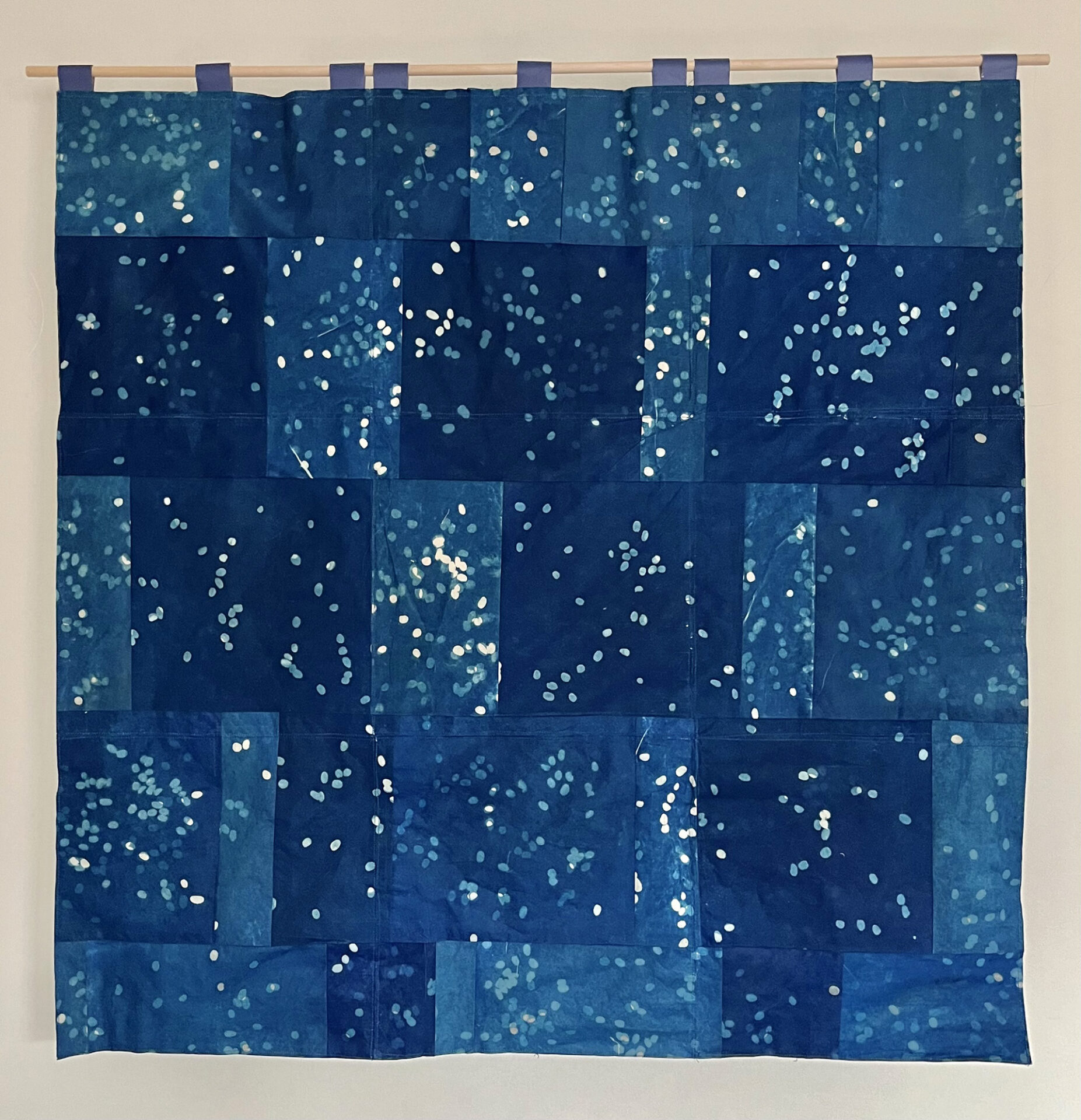 Back of a decorative hanging "quilt" made from used coffee filters with cyanotype imagery