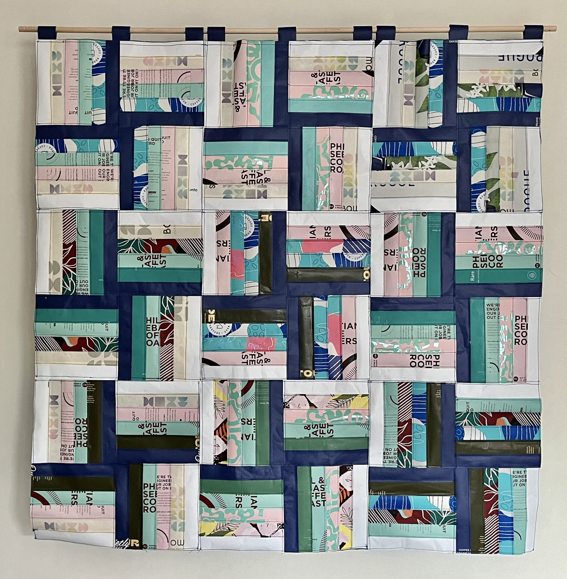Front of a decorative hanging "quilt" made from colourful coffee bags