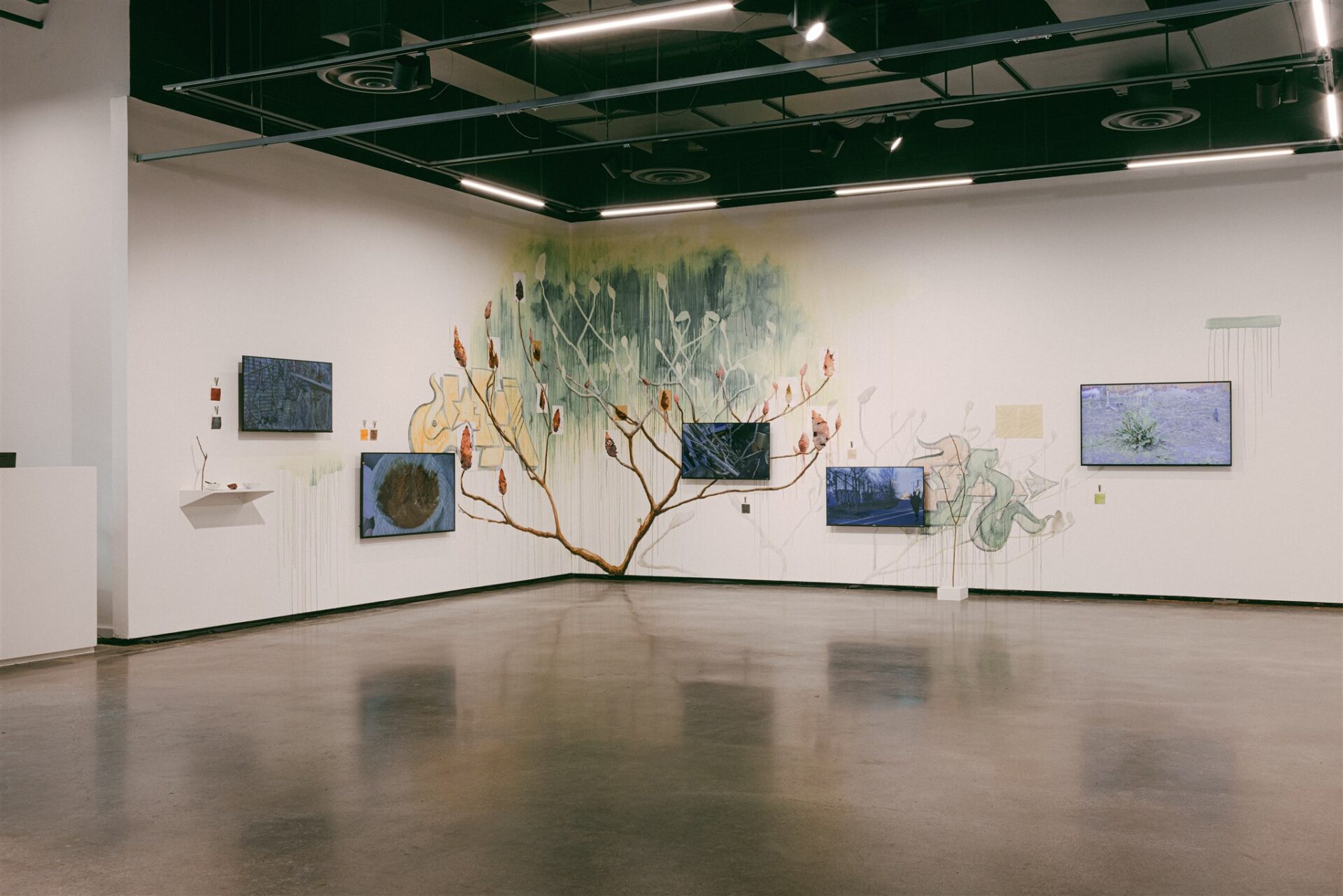 Wall mural of a tree with video screens and mixed media elements