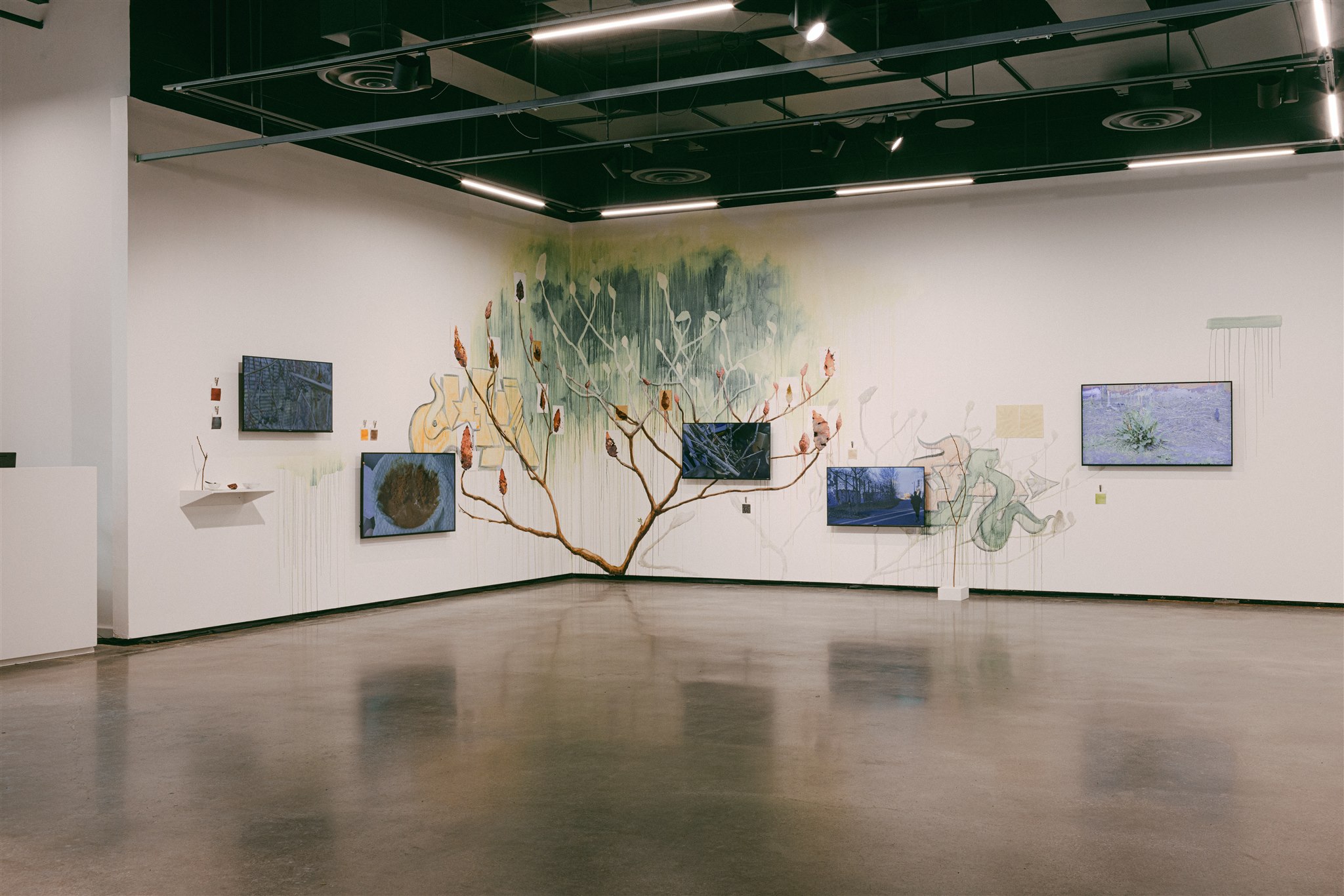Wall mural of a tree with video screens and mixed media elements