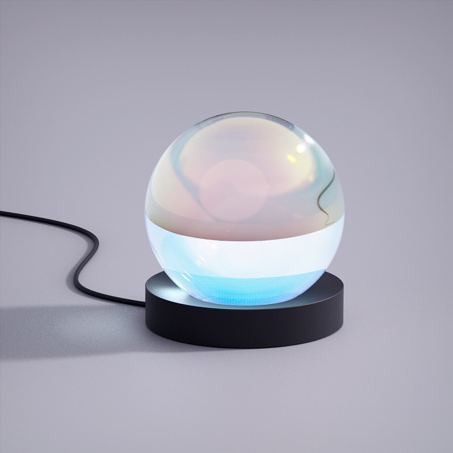 An iridescent glass sphere set on a black base against a grey backdrop