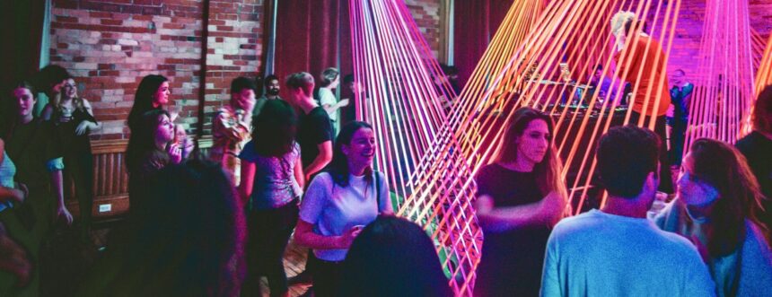 People dancing at party with art and light installation