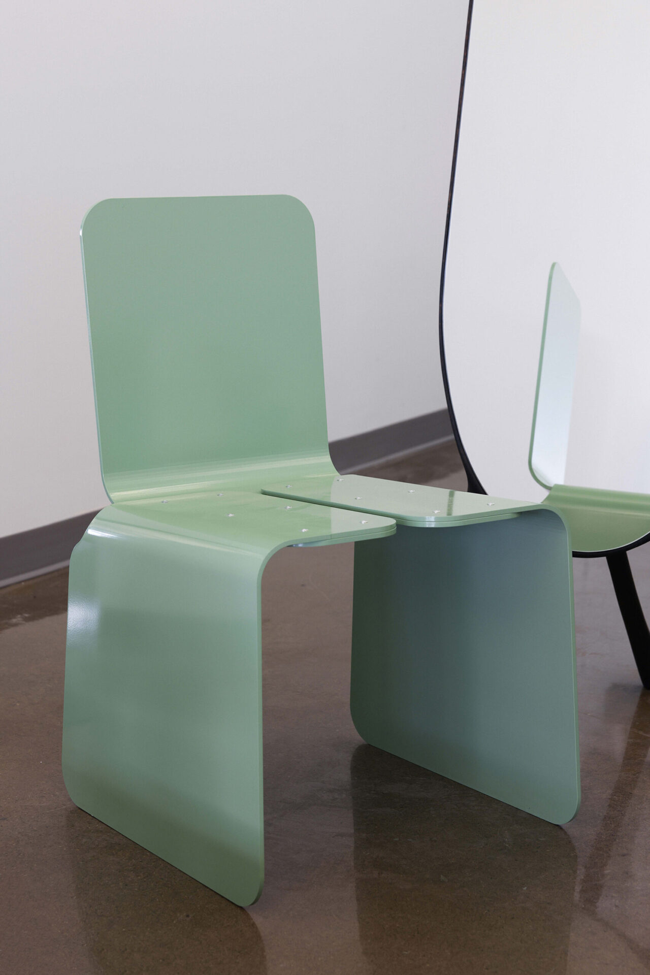 green chair with a mirror behind