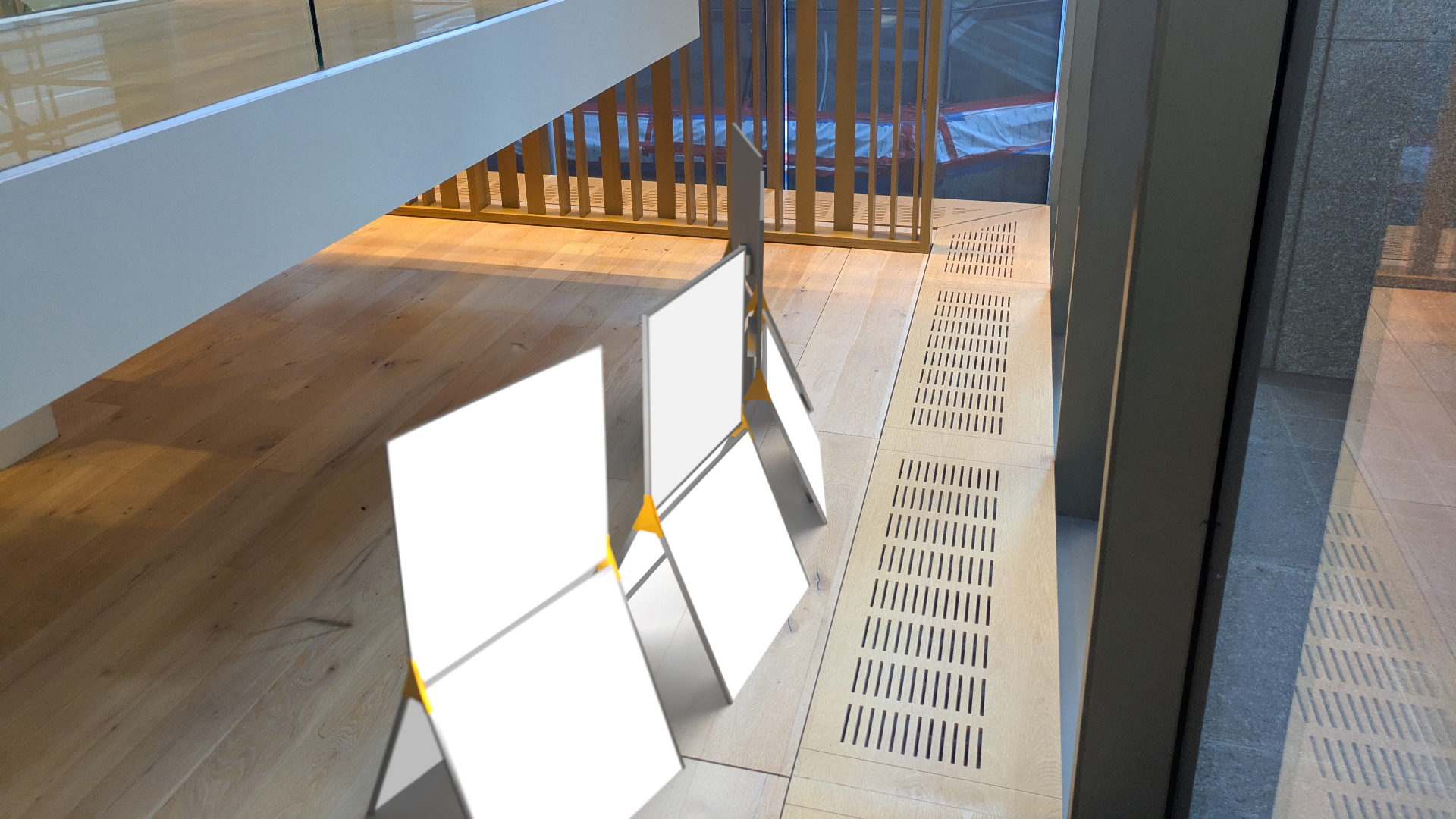 4 custom lighting devices created from standard square LED panels. They are shown on a wood floor in front of large windows