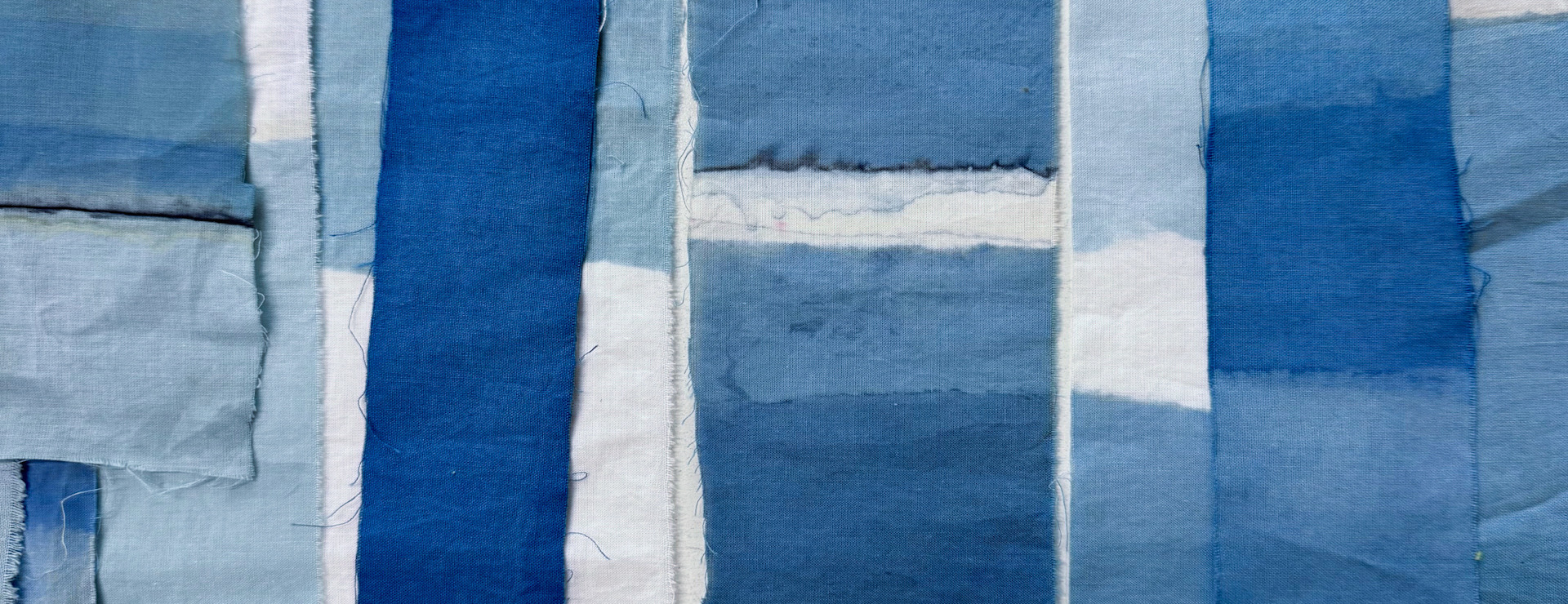 numerous indigo blue dyed pieces of cotton fabric in a grid like arrangement