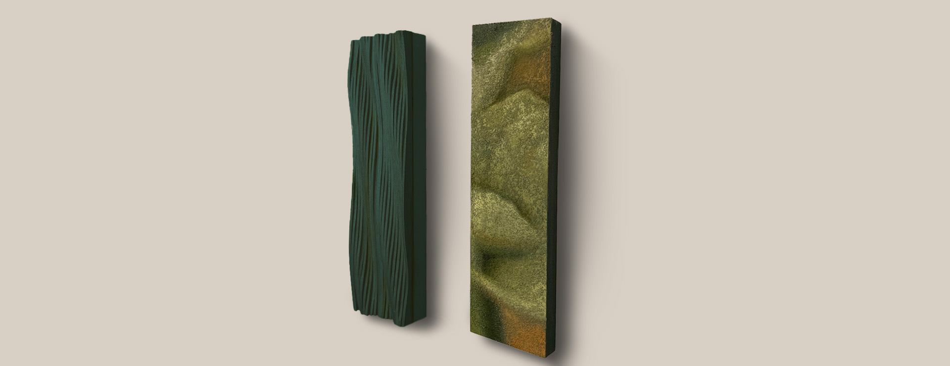 Two pieces of art hang on a blank wall. The left one is made out of wood that has been sculpted into a wave form. The right one has a 'fuzzy' paint application and resembles an abstracted flower.