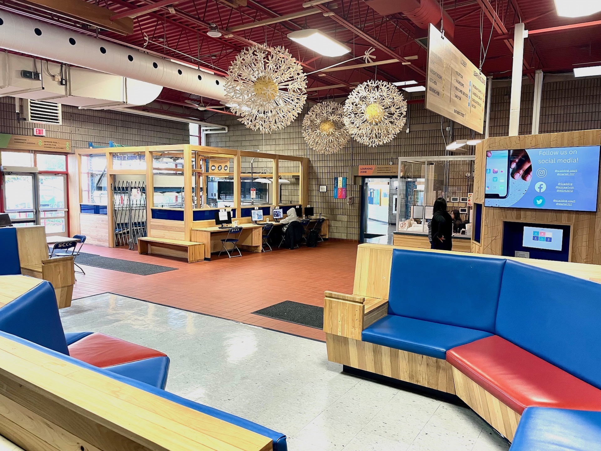 Scadding Court Lobby showing dandelion sculptures, seating, computer stations and aquaponics area