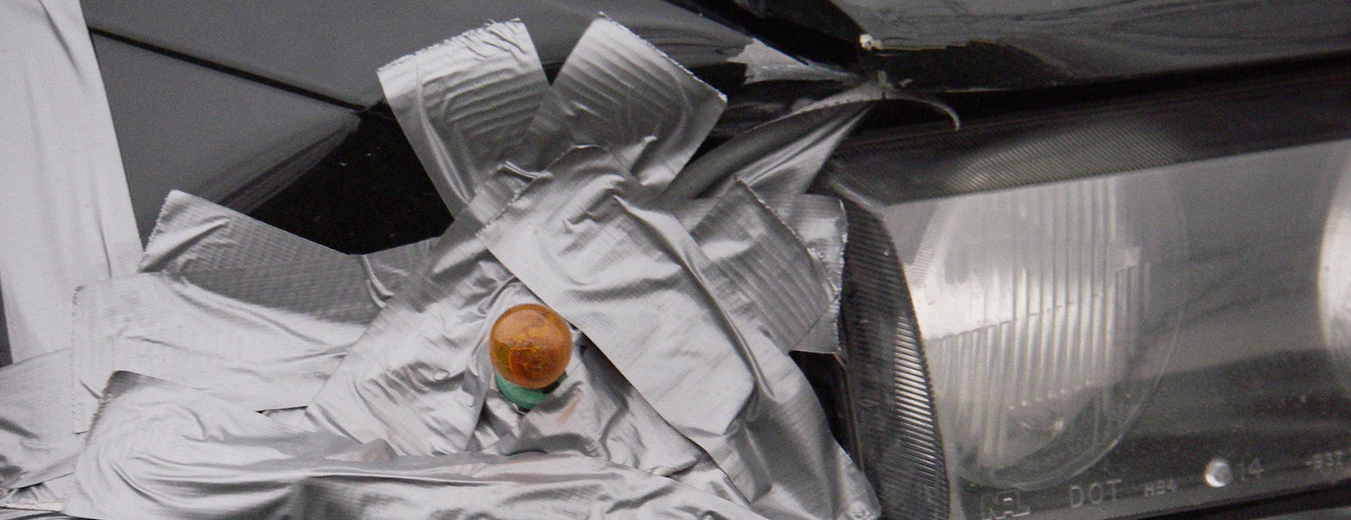 Black car front bumper, duct-taped together post accident