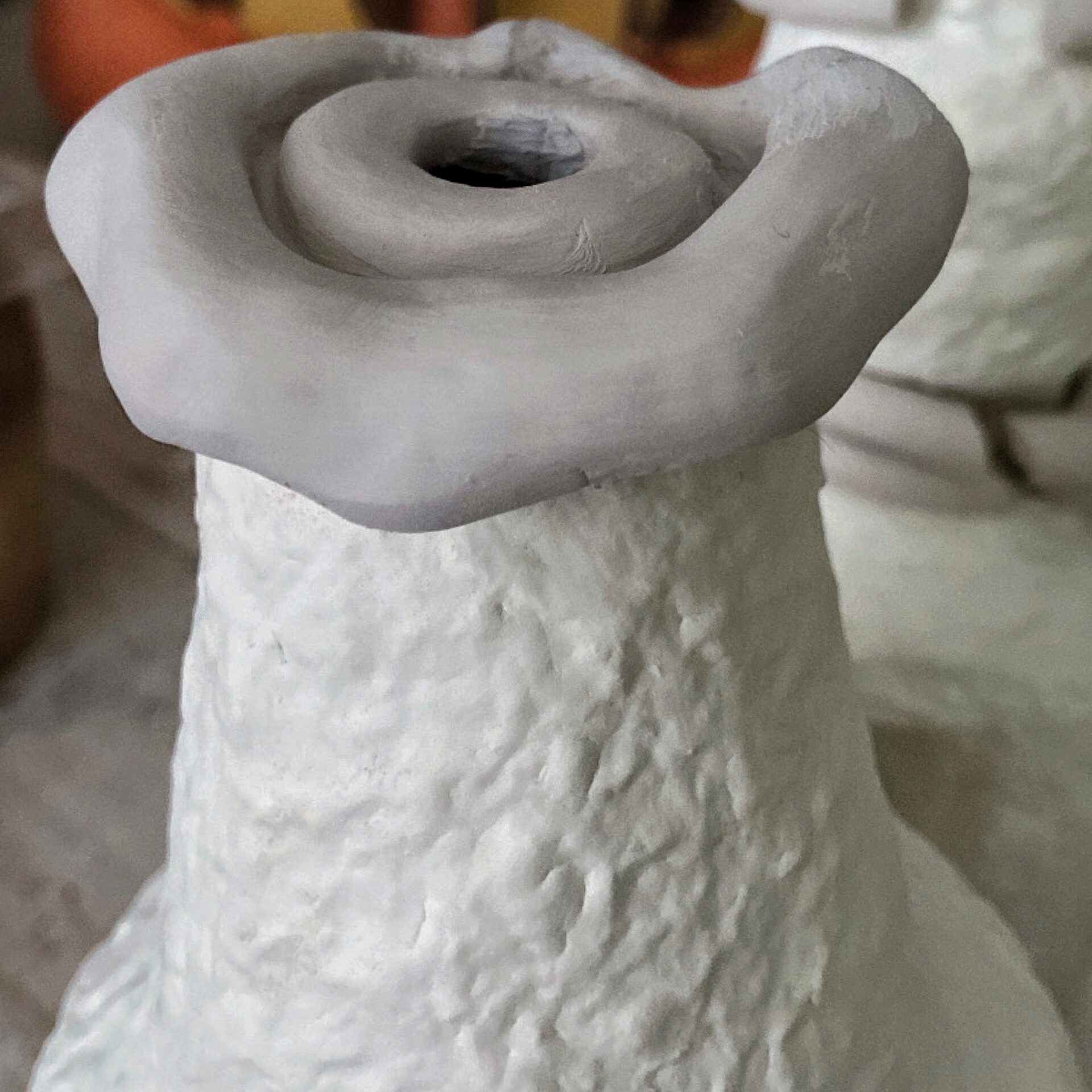 Detail of the top of vase, clay and cardboard pulp.