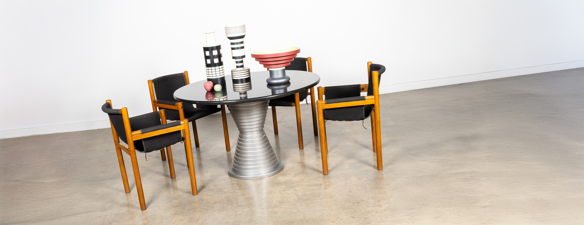 1980s Marble Top Hourglass Base Dining Table, and Set of 4 Sling Chairs by Ibisco, topped with a selection of Bitossi Ceramics by Italian Designer Ettore Sottsass.