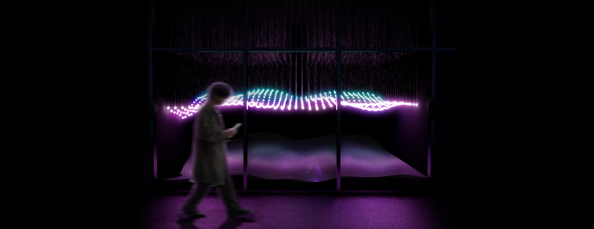 A blurred figure walks past a large glass window glowing with waves of light. Inside the display, hundreds of suspended points of illumination form a rhythmic, patterns that stretch horizontally across the dark space. The lights shimmer in hues of violet, pink, and turquoise, flowing like a soft current. Beneath the illuminated waves, the terrain rises and dips gently, its surface catching faint reflections of the colors above.