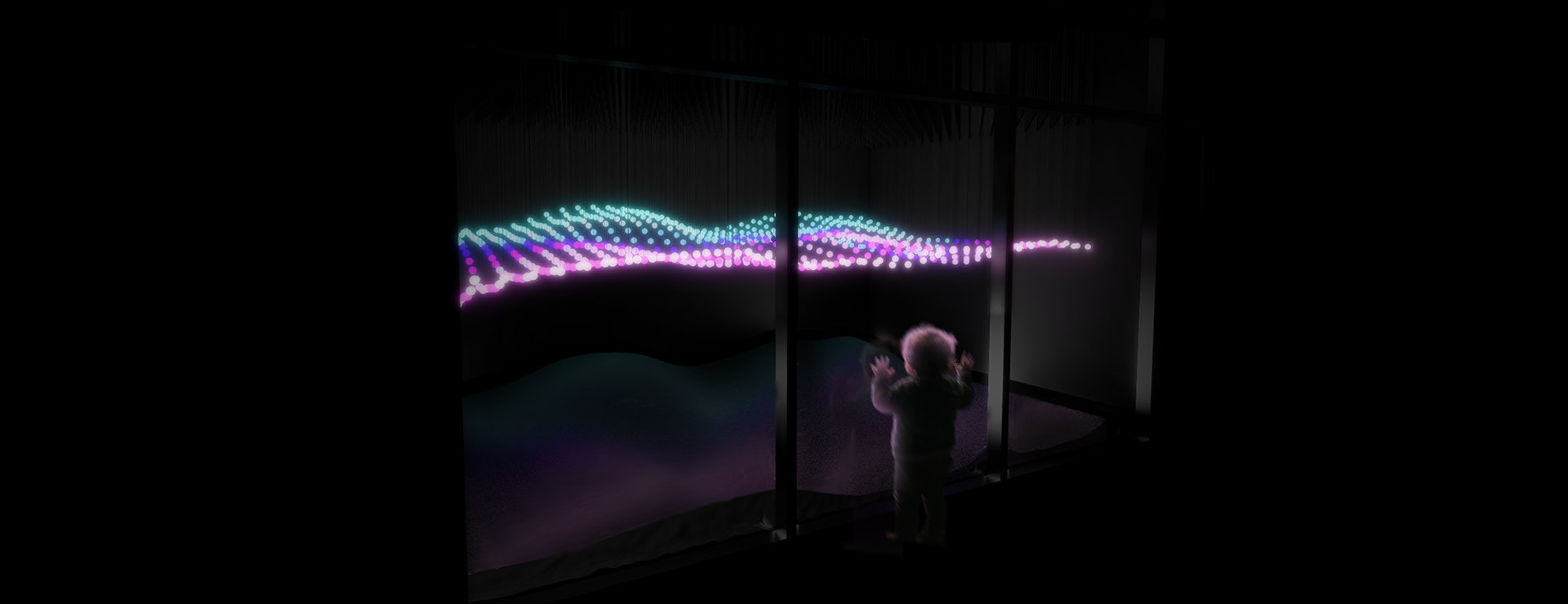 A small child stands in front of a large glass window, reaching out toward a glowing display inside. Beyond the glass, hundreds of tiny suspended lights form a gentle, wave-like pattern that ripples horizontally across the dark space. The lights shift between soft shades of blue, pink, and violet, creating the illusion of movement, like the Northern Lights floating in midair.