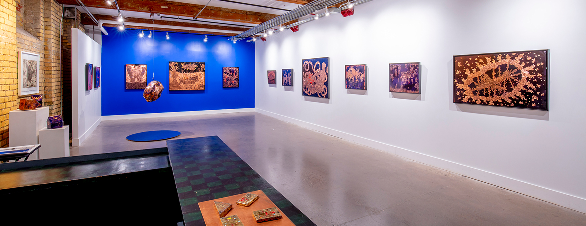 A gallery with art pieces on the wall.