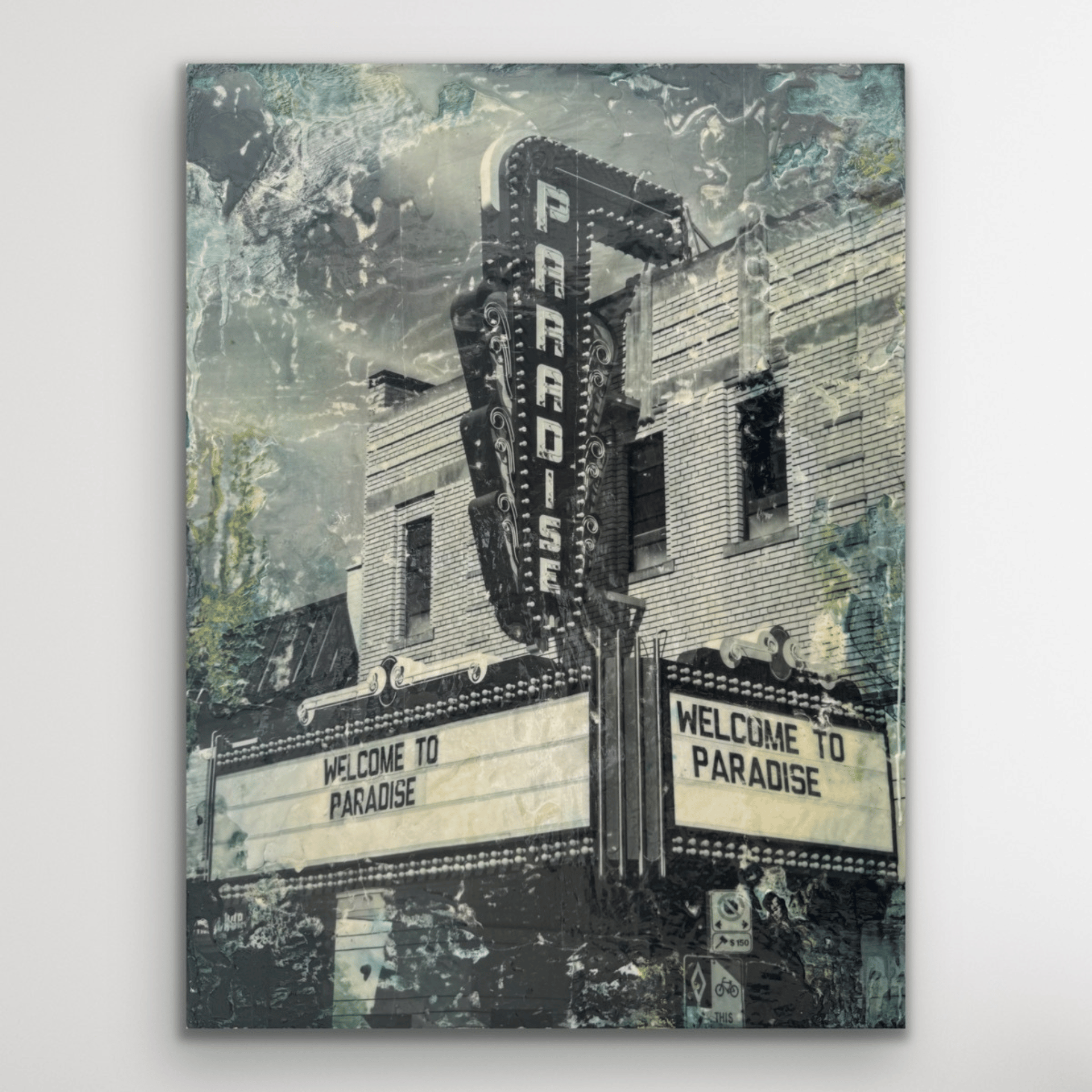 Black and white photograph of a movie theater sign that reads "Paradise". The marquee displays the words "This is paradise". Spatters of paint and encaustic wax surround the image. 
