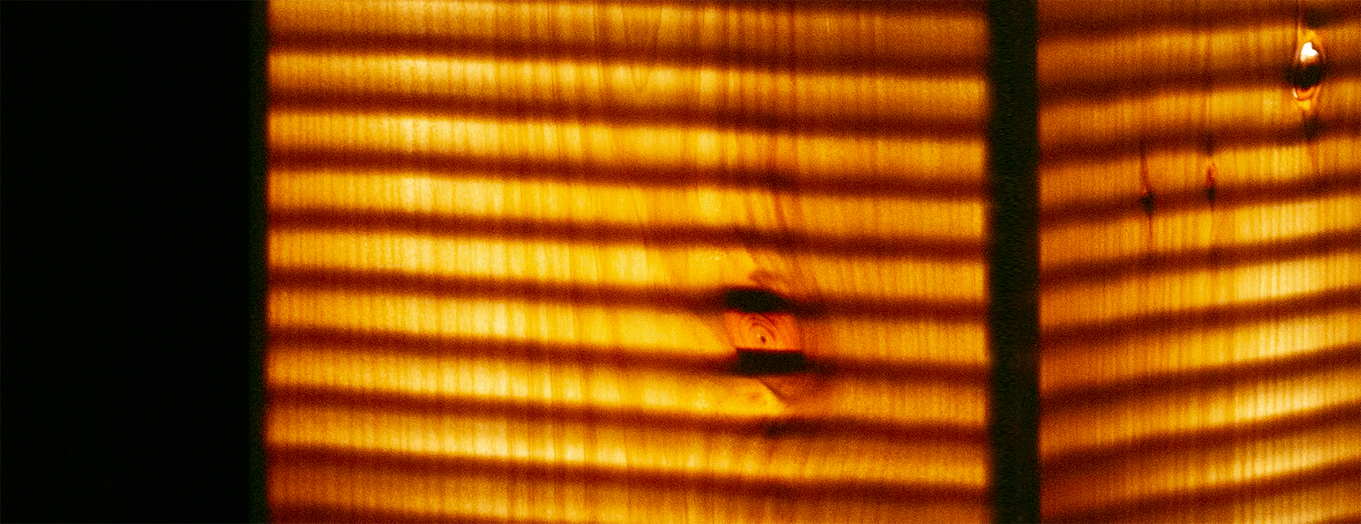 Close up image of stripes of wood texture spaced by black lines.
