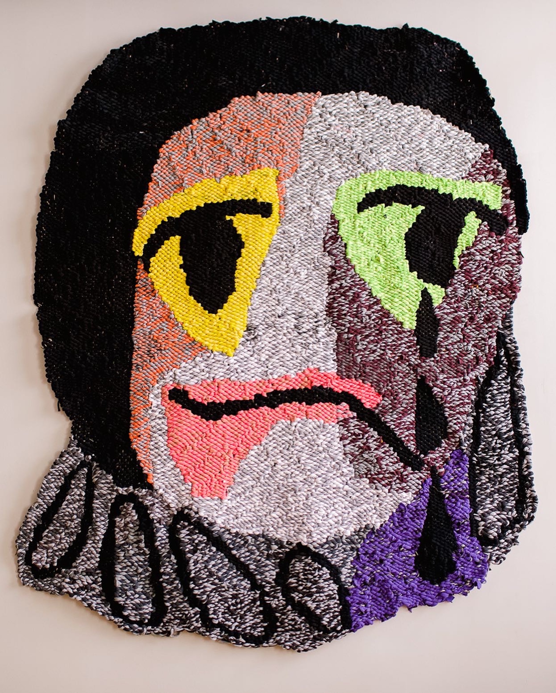 Large scale weaving of Pierrot and is made from t-shirt yarn. It is black, purples, pinks and white.