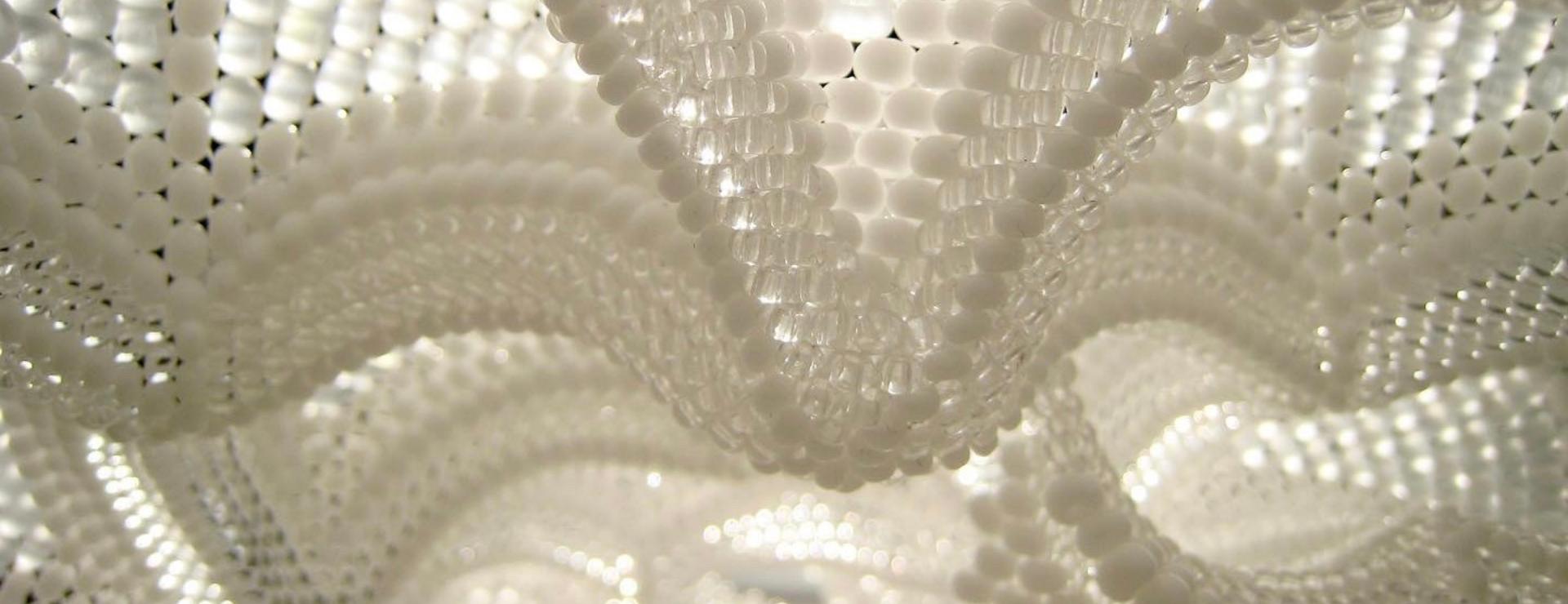 Arches of white glass beads that look like the vaulted ceiling of a cathedral glowing with light