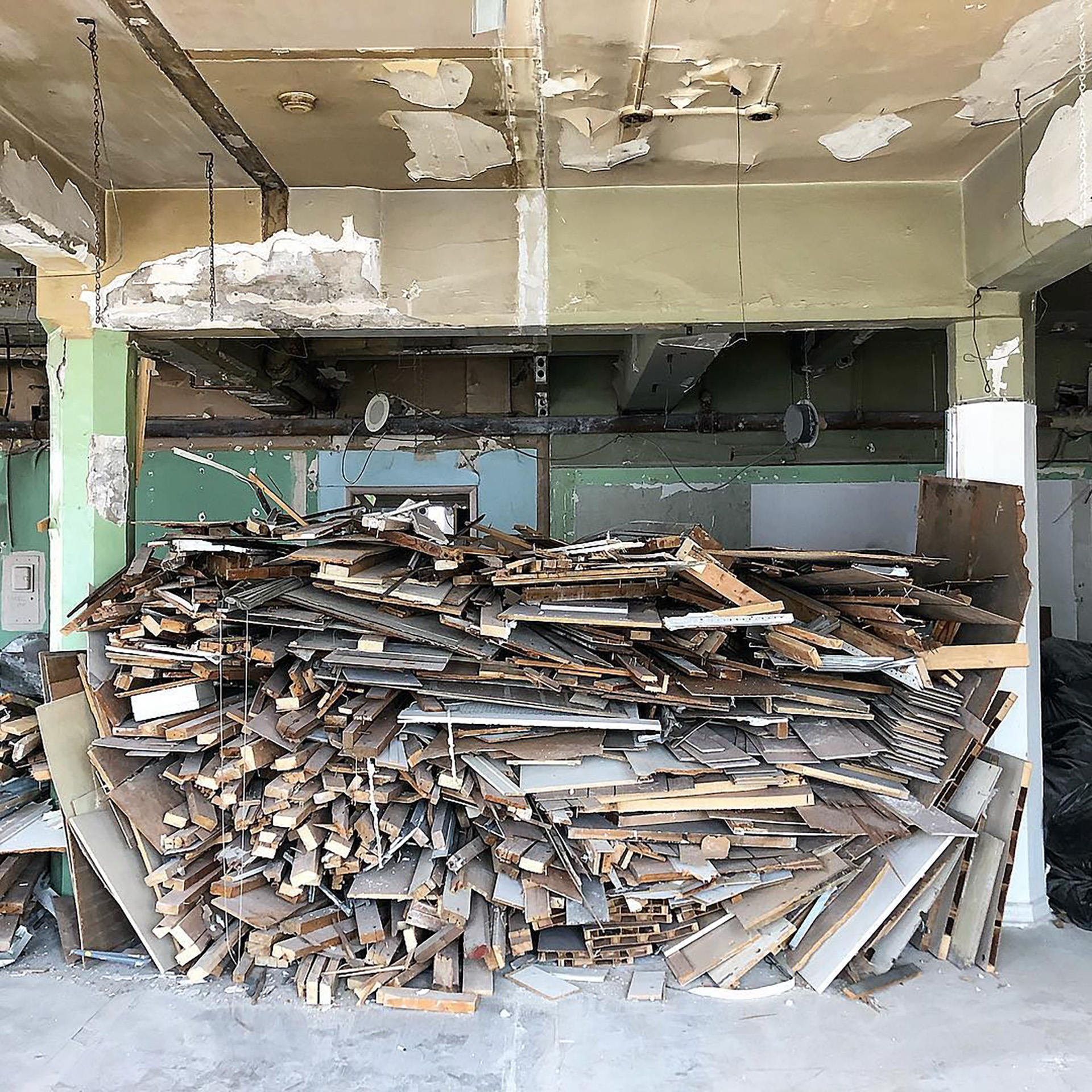 Salvaged lumber piled in a room in the midst of renovation.