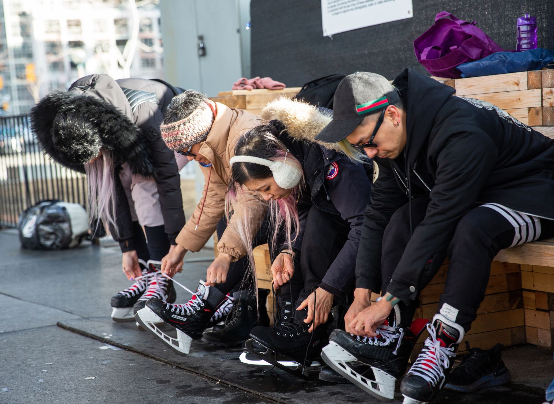 Skaters tying up ice skates at The Bentway