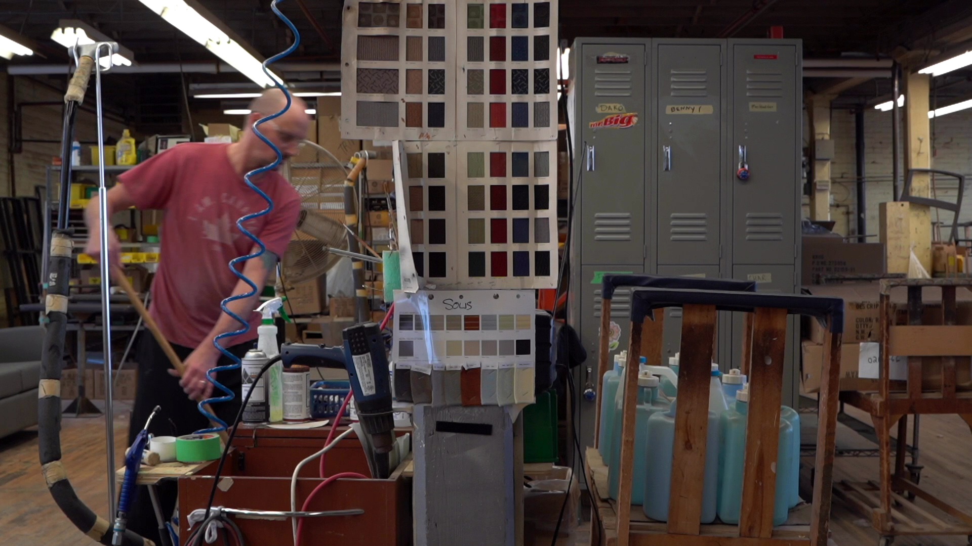 Factory scene with lockers, colour swatches, air compressor, worker sweeping floor in background