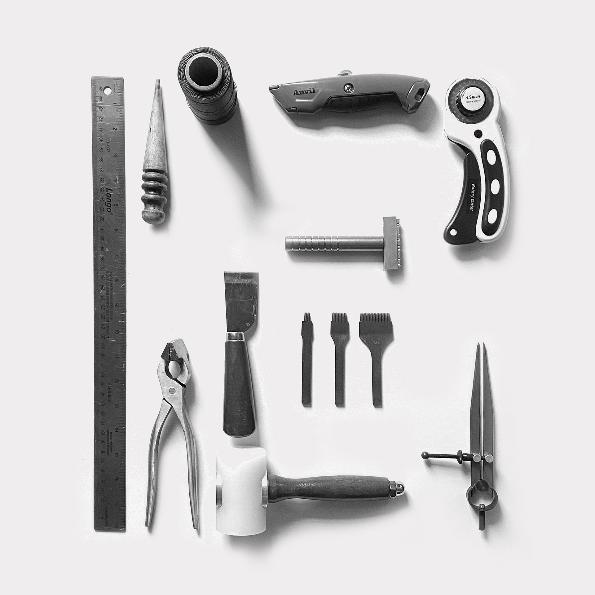 Leatherworking tools displayed in grid on gray background.