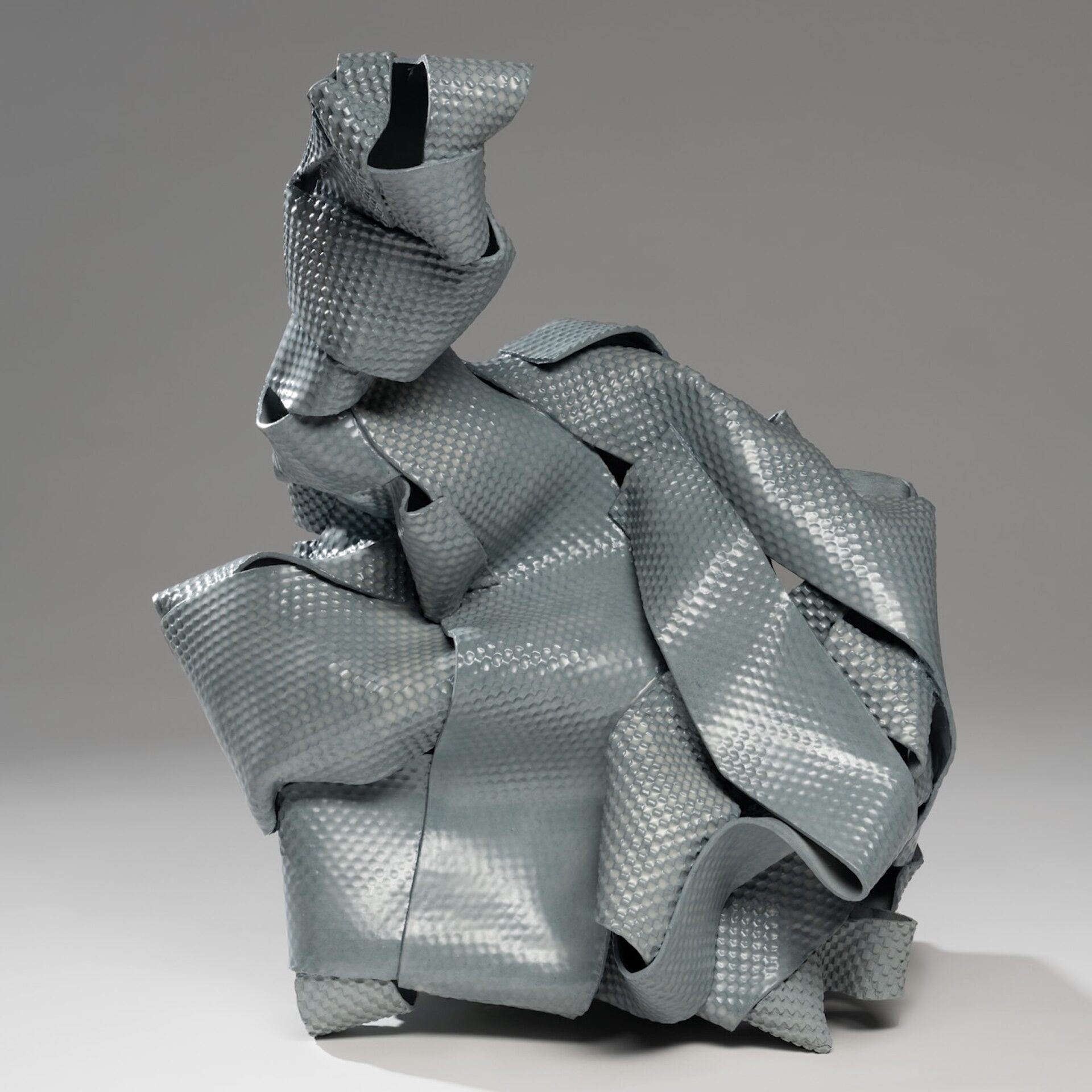 slate blue ceramic sculpture made with ribbon-like strips of textured clay