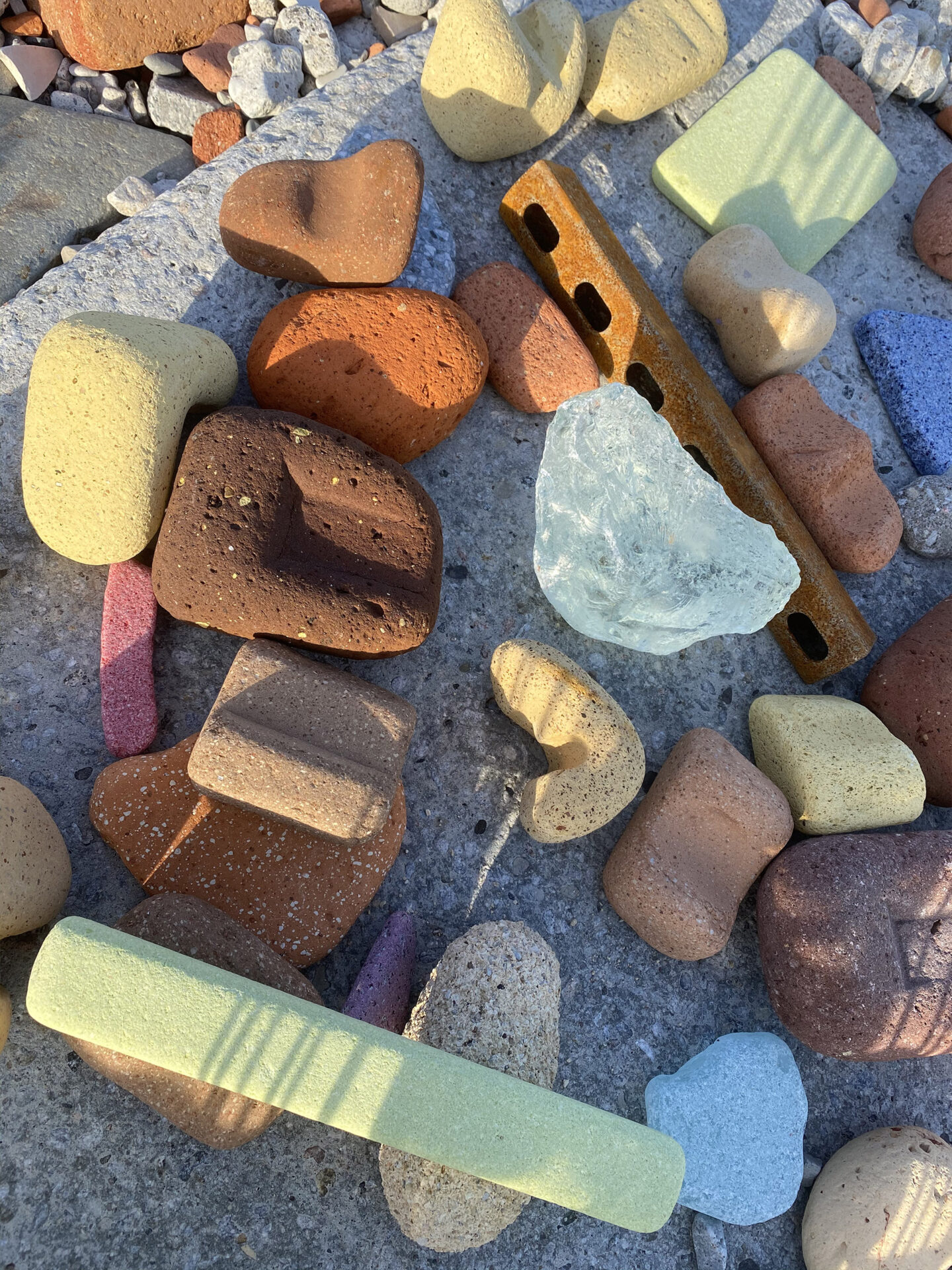 A small pile of yellow, brown, orange, pink, and blue bricks with soft edges.
