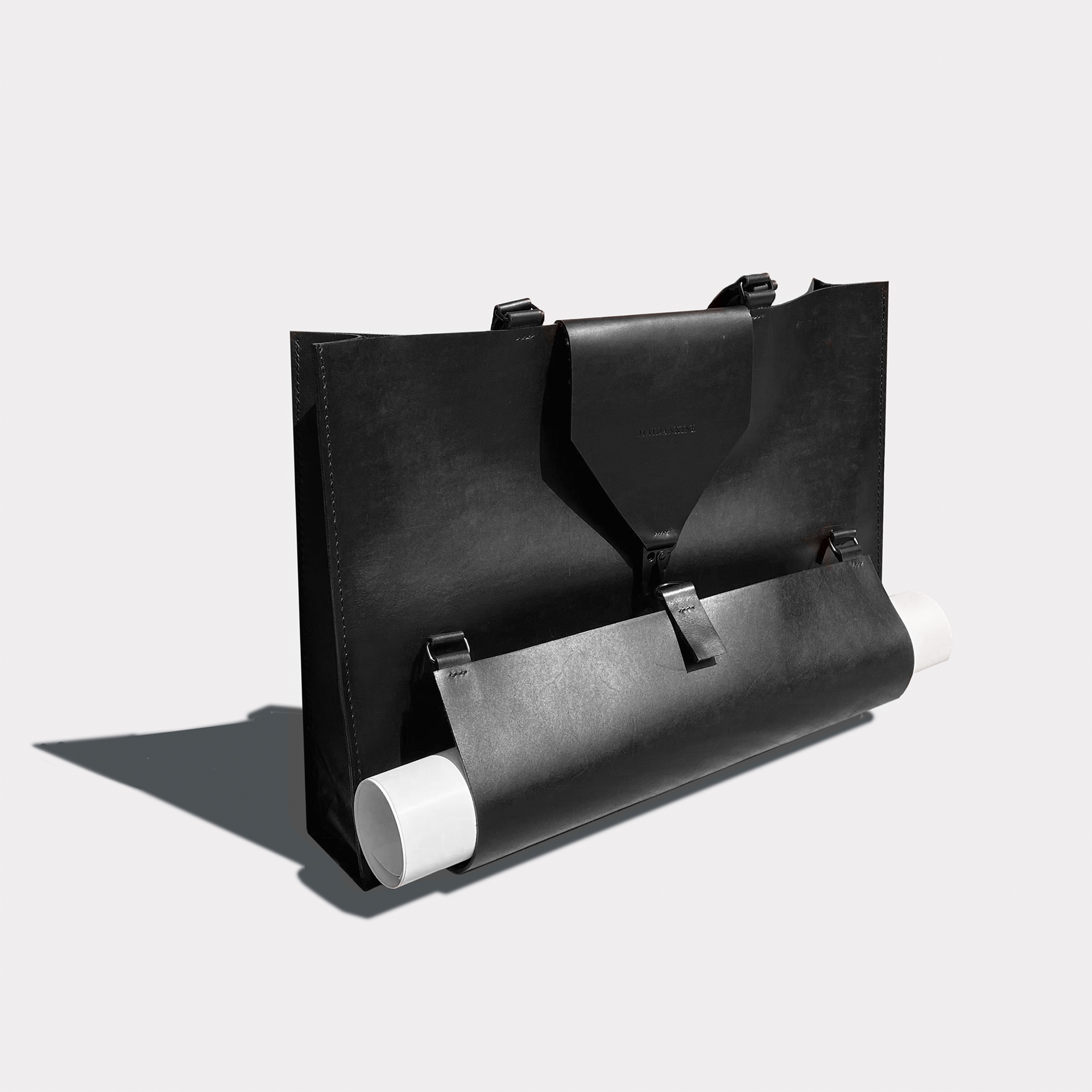 Black leather tote on gray background.