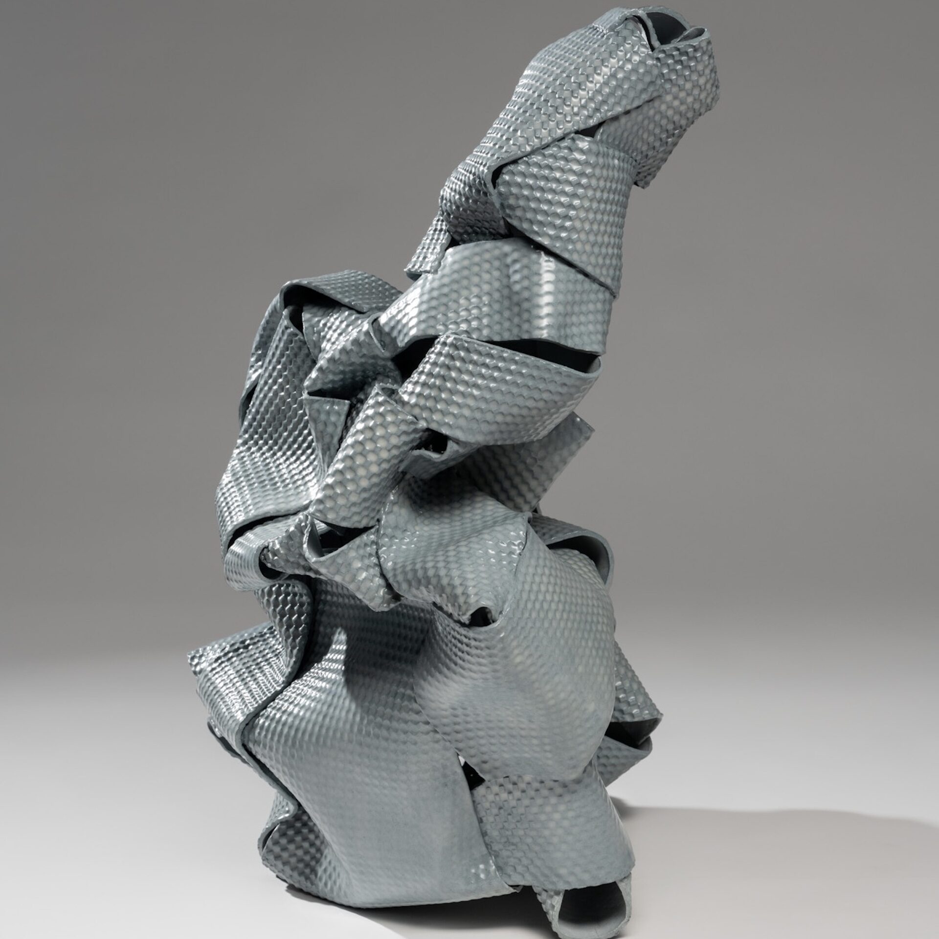 slate blue ceramic sculpture made with ribbon-like strips of textured clay