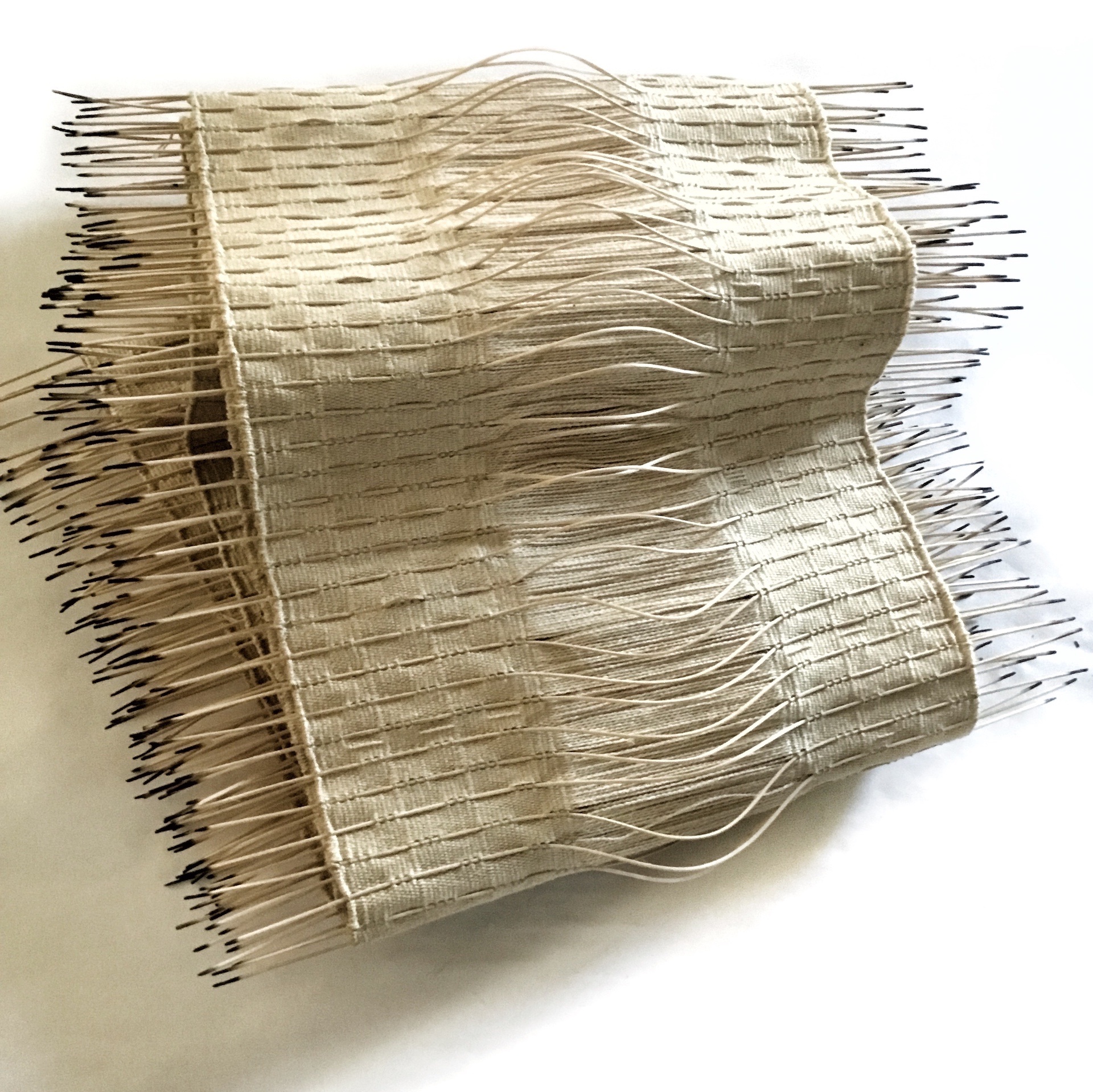 folded woven rattan and cotton with burnt edges