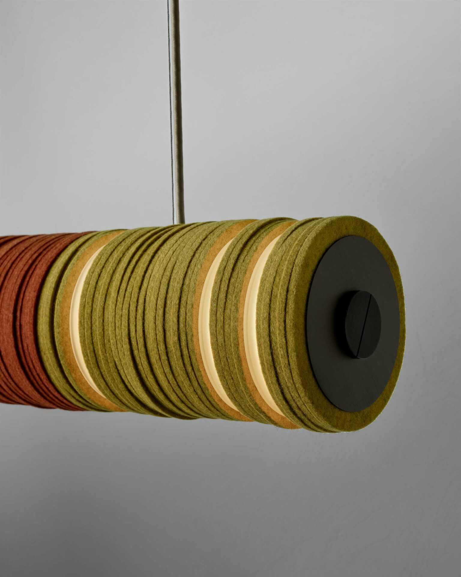 Close up of a pendant light made from circles of felt in yellow and orange